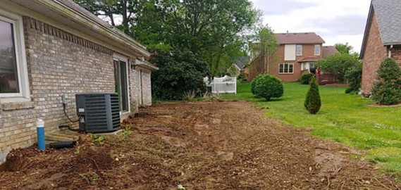 Photo of an empty dirt spot next to home after deck removal