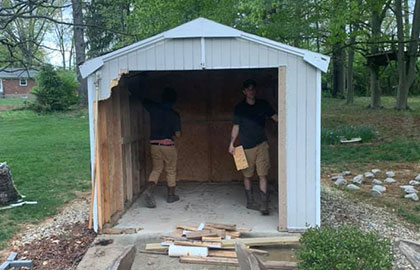 Workers demolishing a shed