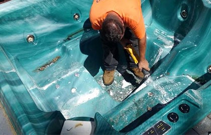 Photo of a worker demolishing an old hot tub